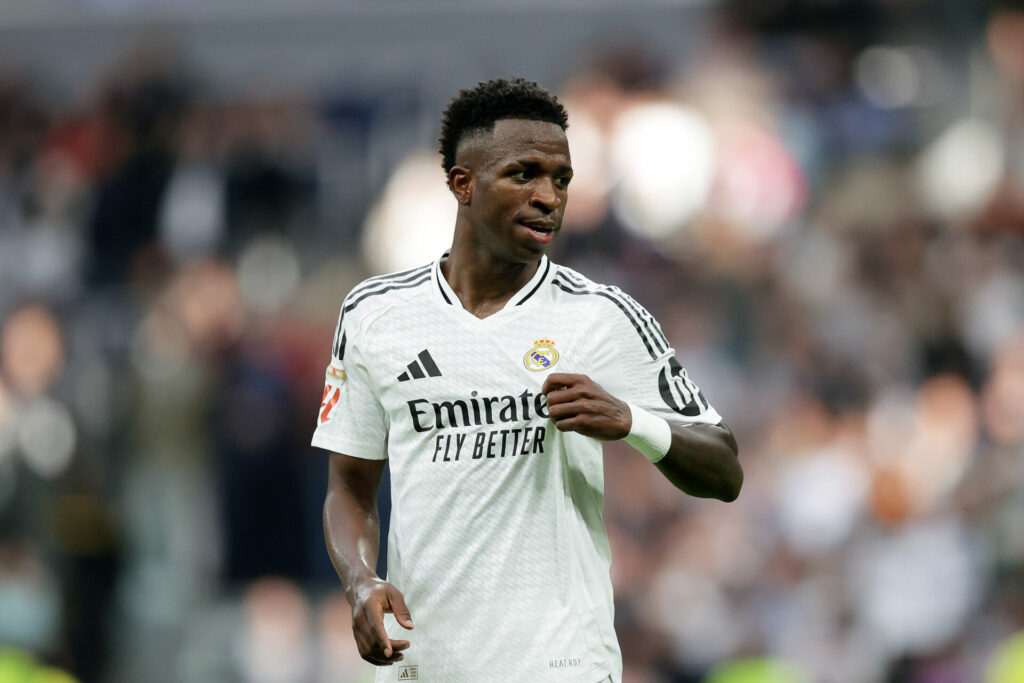 Vinicius celebra un gol señalando el escudo del Real Madrid.