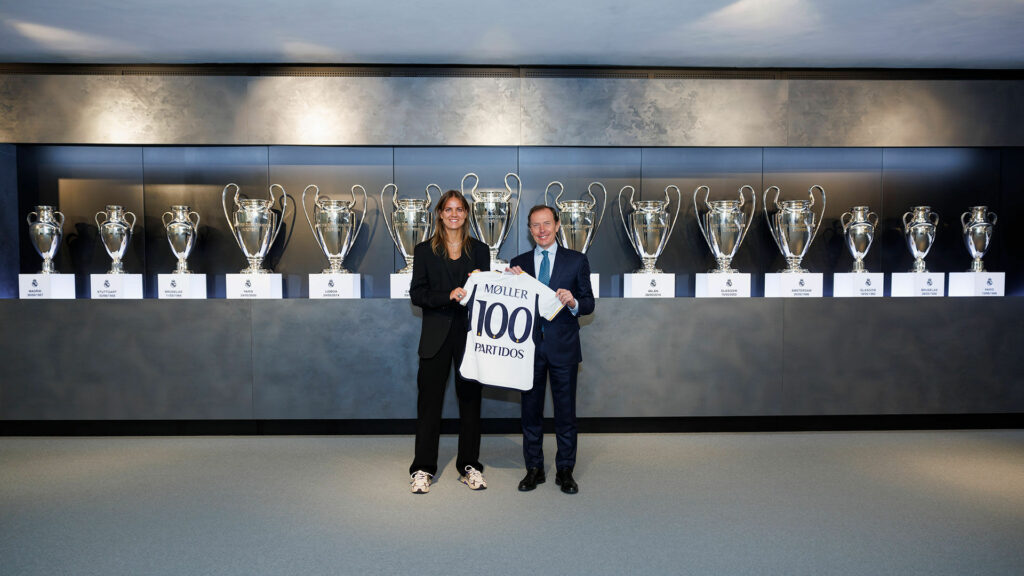 Caroline Møller posa, junto a Emilio Butragueño, con la camiseta conmemorativa de cien partidos con el Real Madrid.