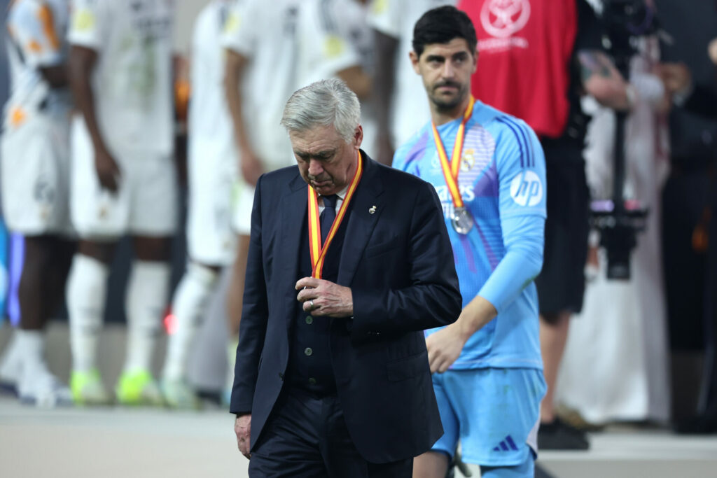 Carlo Ancelotti mirando la medalla de subcampeón de la Supercopa de España.