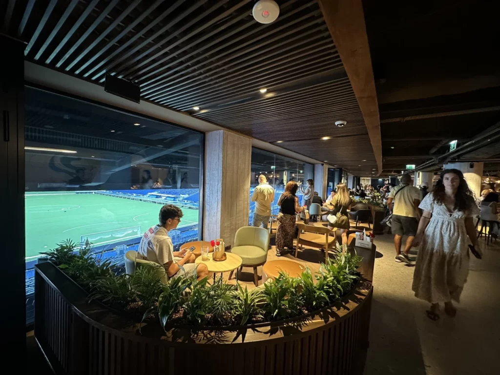 Interior del Starbucks del Santiago Bernabéu, clientes y vistas al estadio desde un gran ventanal