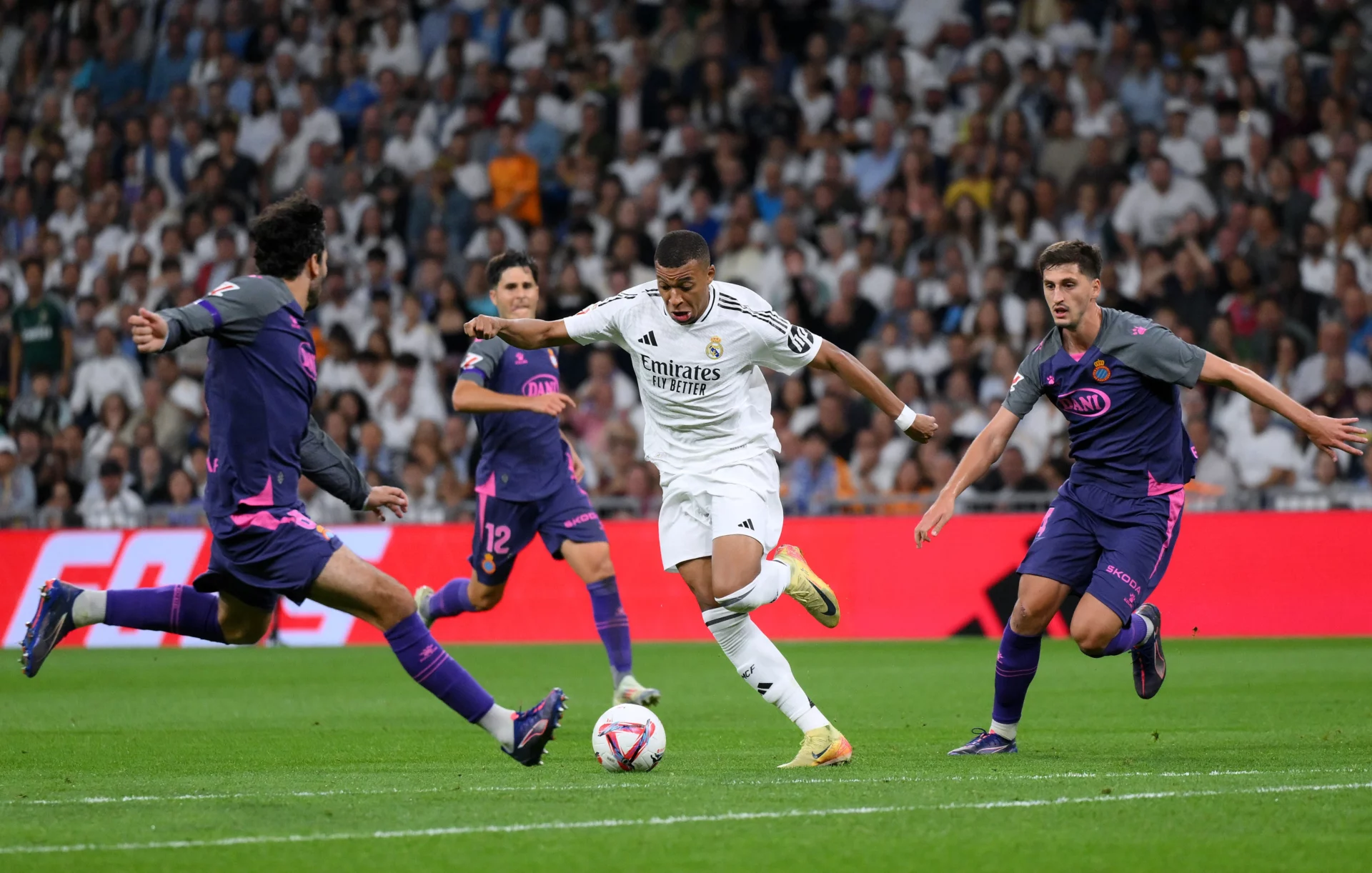Los jugadores del RCD Espanyol rodean a Kylian Mbappé, del Real Madrid, en el Santiago Bernabéu