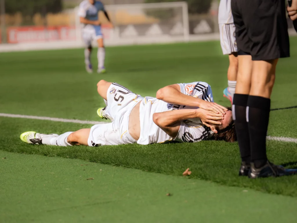 Joan Martínez, tendido en el suelo con las manos en la cara, durante el partido entre Real Madrid Castilla y Racing de Ferrol