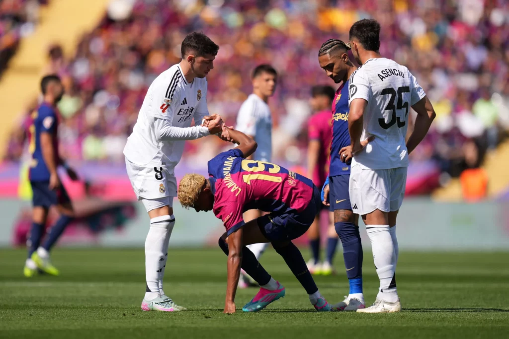 Fede Valverde levanta a Lamine Yamal del suelo durante un Clásico entre Barcelona y Real Madrid