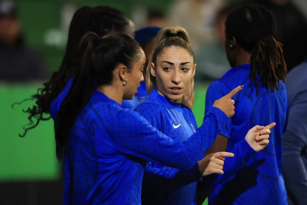 Olga Carmona habla con Sakina Karchaoui antes de un partido del París Saint-Germain.