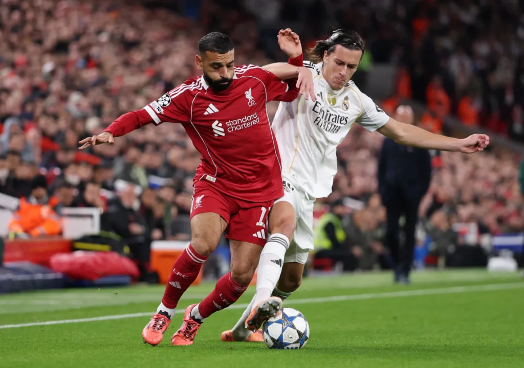 Álvaro Carreras y Salah pugnan por el balón durante el Liverpool - Real Madrid en Anfield.
