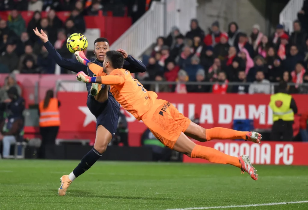 Gazzaniga despeja con el puño la pelota delante de Mbappé durante el empate entre Girona y Real Madrid.