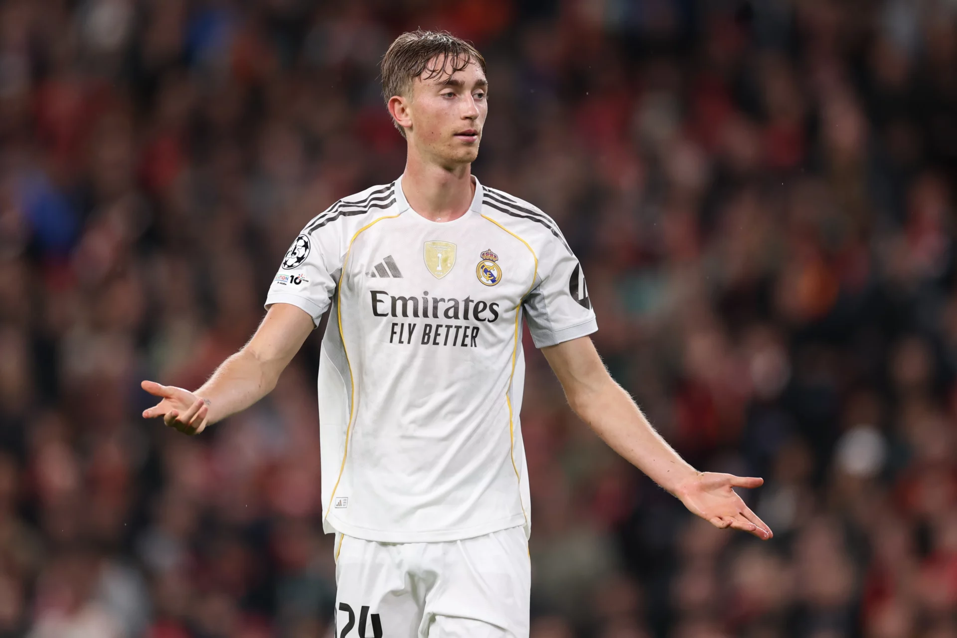 Huijsen abre los brazos durante un partido con el Real Madrid.