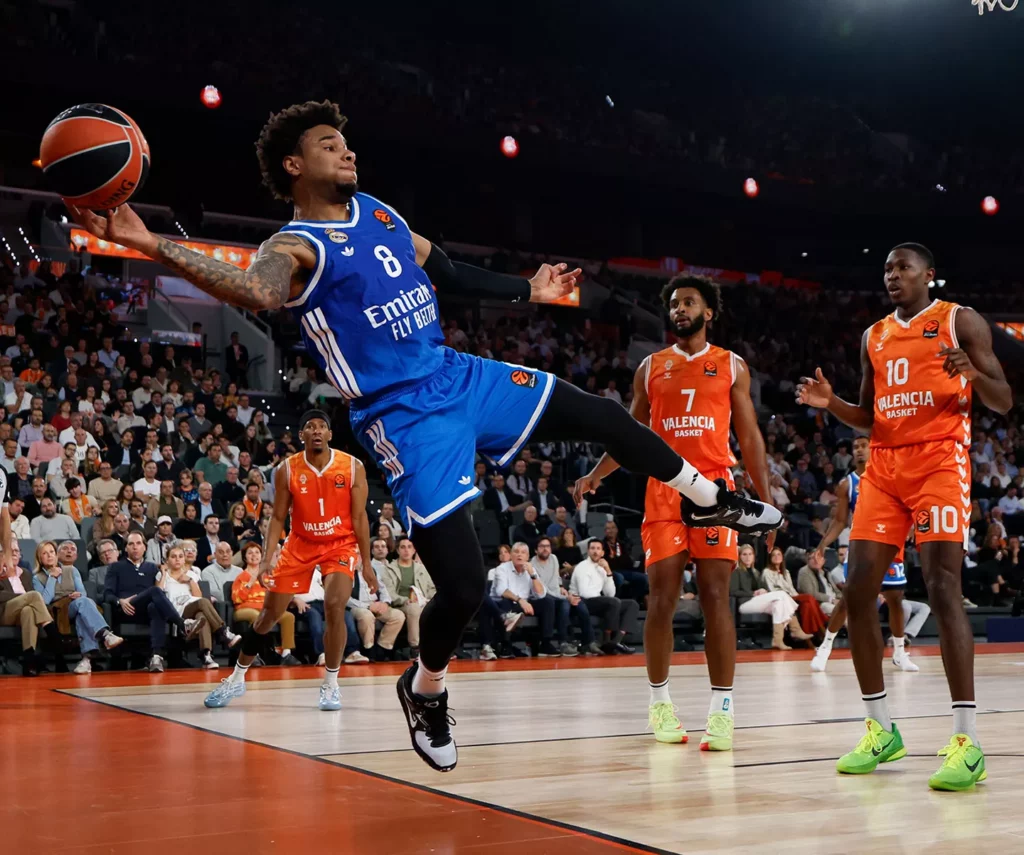 Okeke evita que un balón salga de fondo durante el Valencia Basket - Real Madrid.