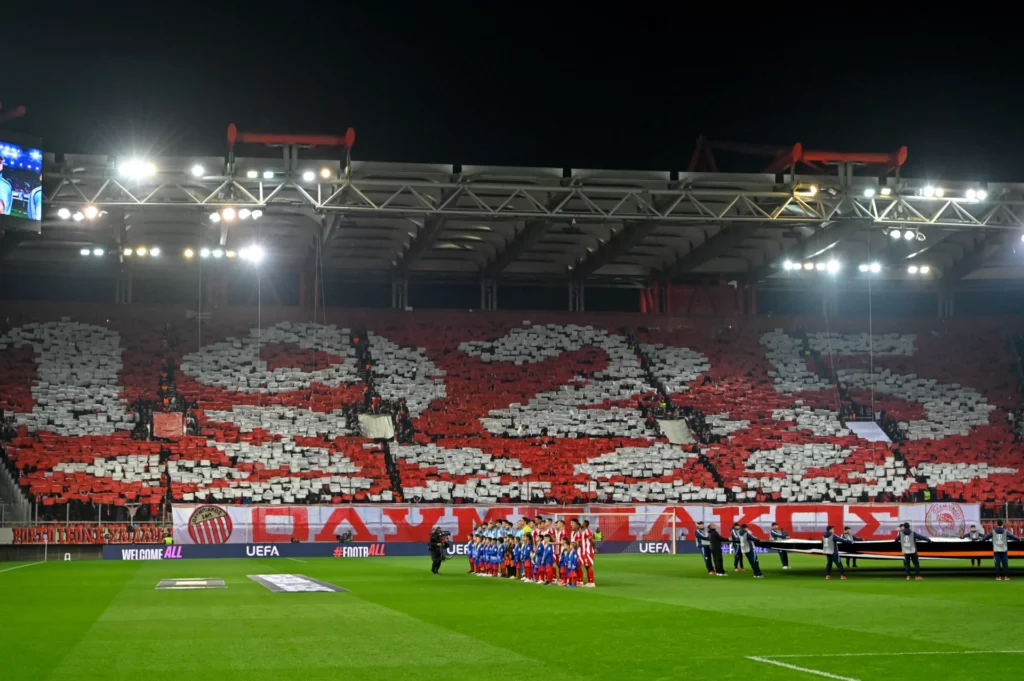 La afición del Olympiacos realiza un mosaico con cartulinas en el Estadio Georgios Karaiskakis.