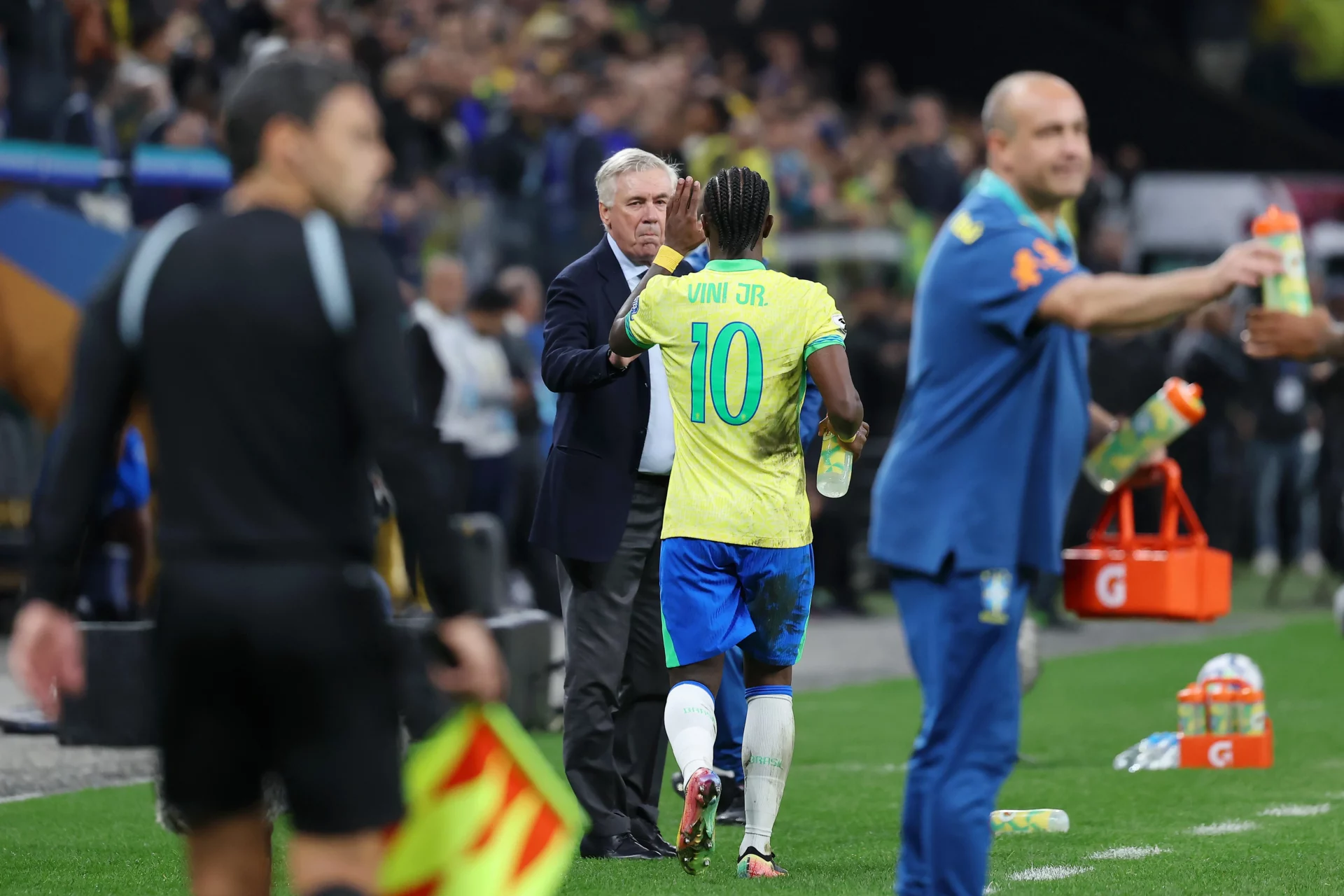 Vinicius y Ancelotti se saludan durante un partido de Brasil.