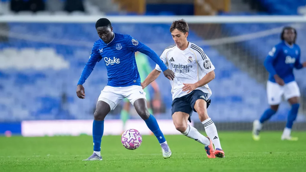 Un jugador del Everton y otro del Real Madrid Castilla luchan por la pelota en Goodison Park.