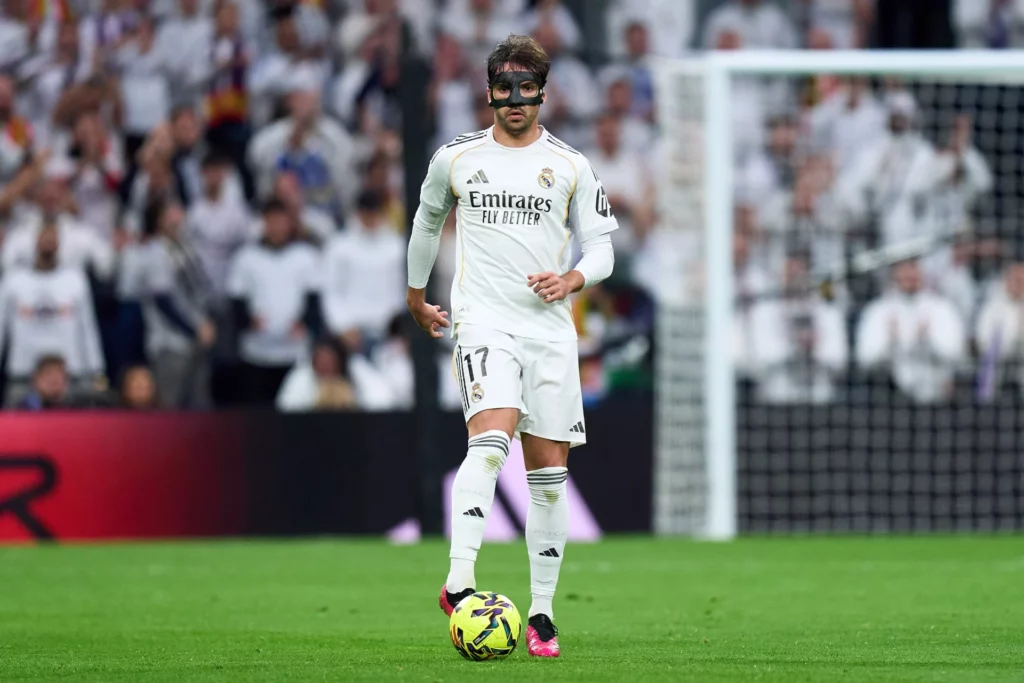 Raúl Asencio controla el balón portando una mascara protectora en su rostro.