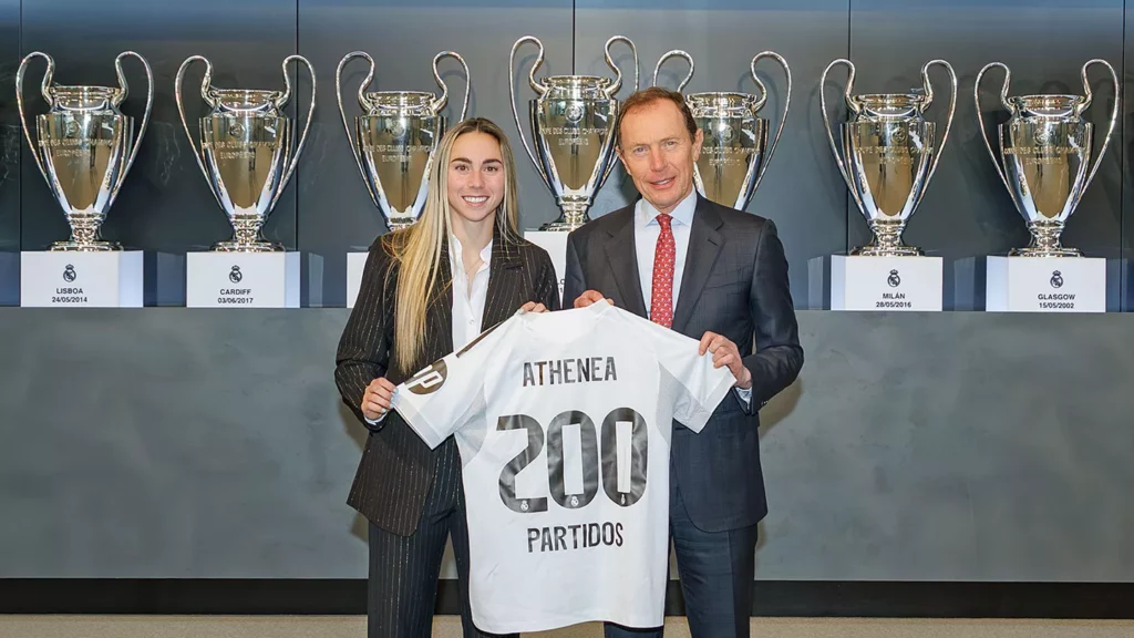 Athenea del Castillo posa, junto a Emilio Butragueño, con la camiseta de 200 partidos disputados con el Real Madrid.