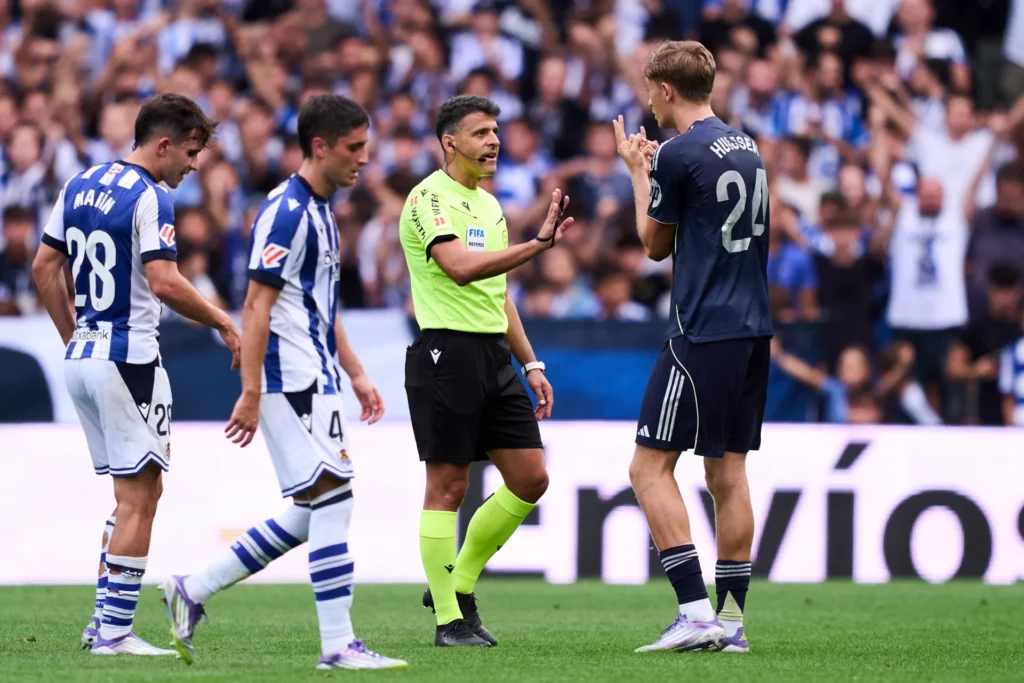 Dean Huijsen protesta a Gil Manzano su expulsión durante un Real Sociedad - Real Madrid.