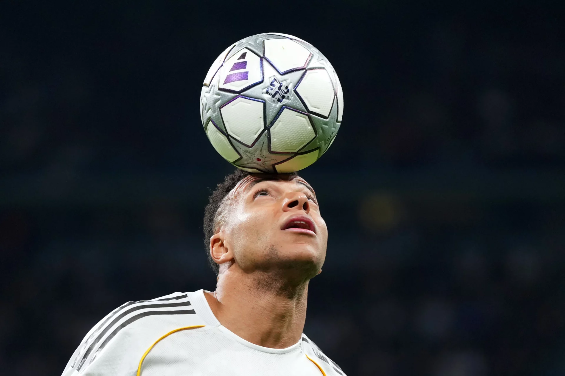 Mbappé controla un balón con su cabeza durante un partido.