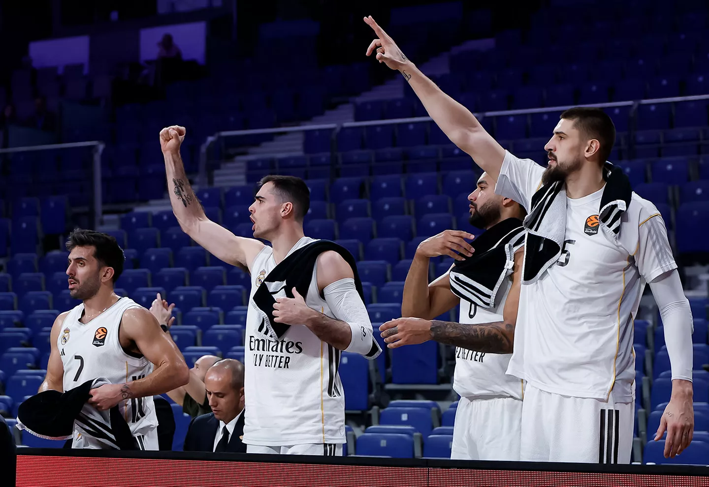 El banquillo del Real Madrid celebra una canasta sin público en las gradas del Movistar Arena.