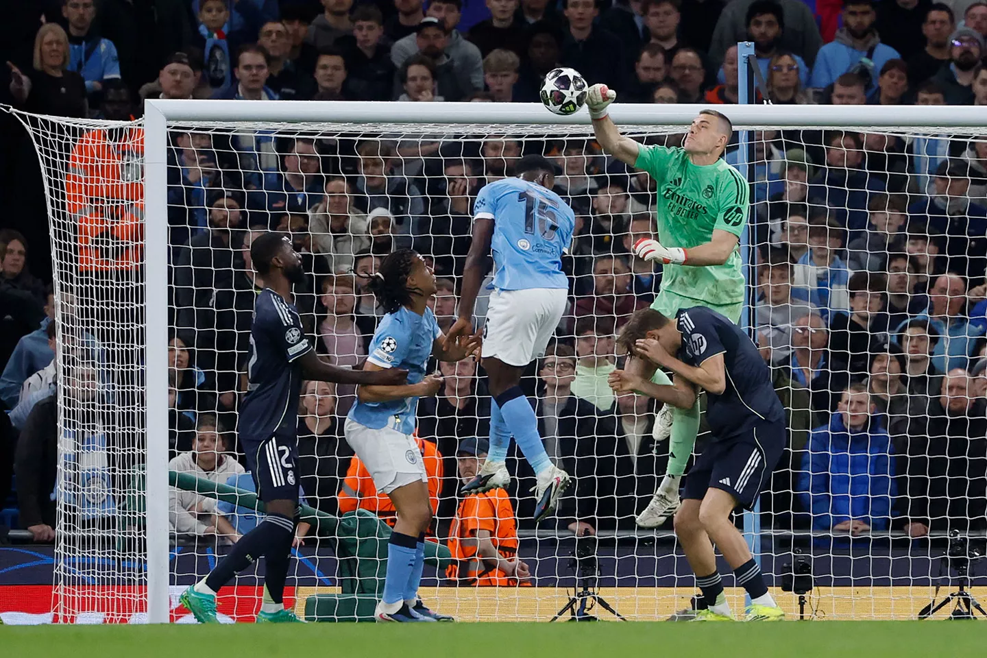Lunin despeja con el puño un balón durante el partido de Champions League frente al Manchester City en el Etihad Stadium.