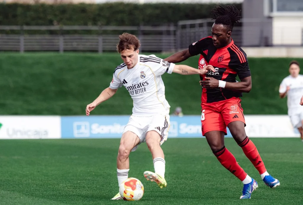 Jugador del Real Madrid Castilla y Ponferradina luchan por la pelota.
