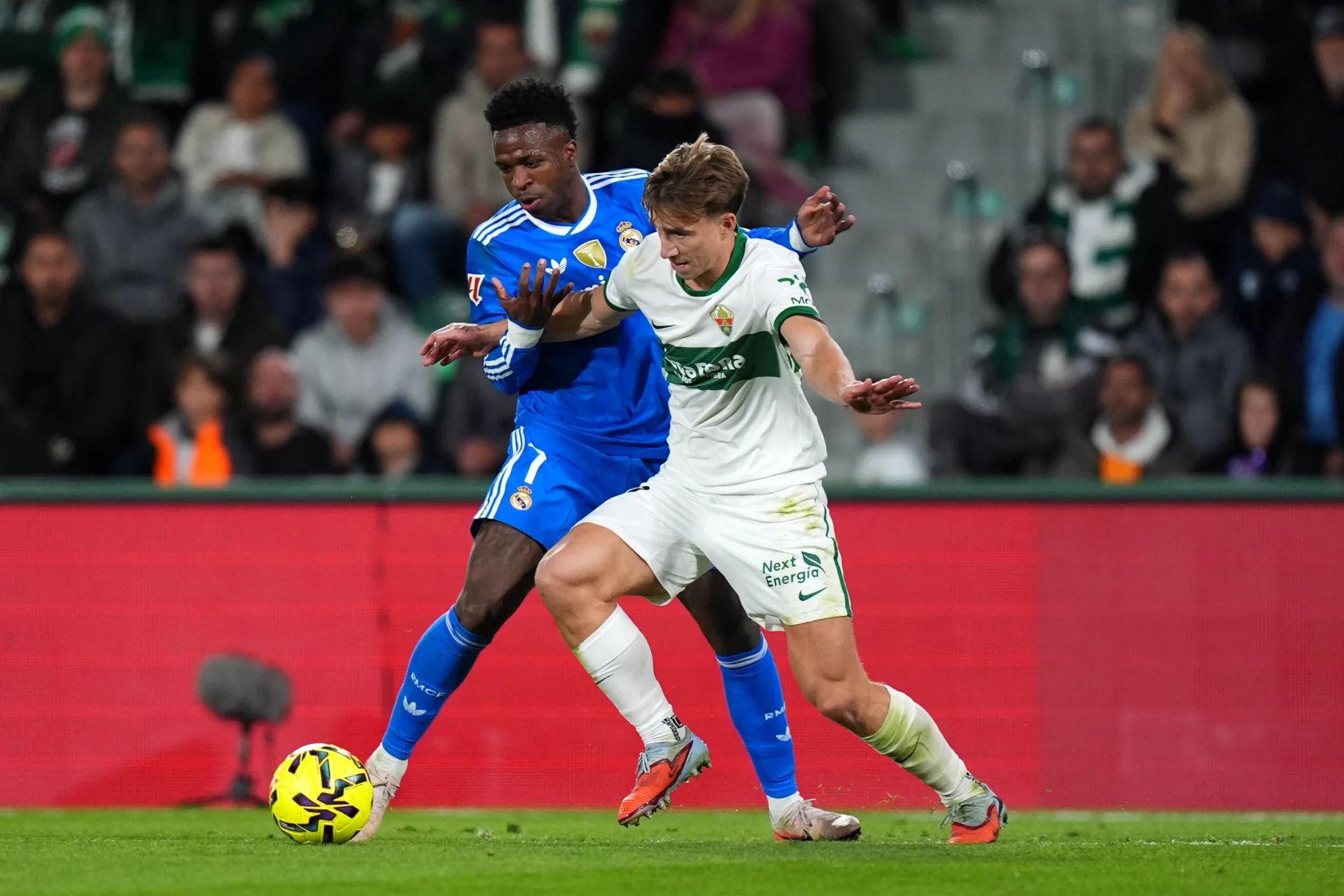 Vinícius, del Real Madrid, disputa un balón con Affengruber, del Elche, en un partido de LaLiga