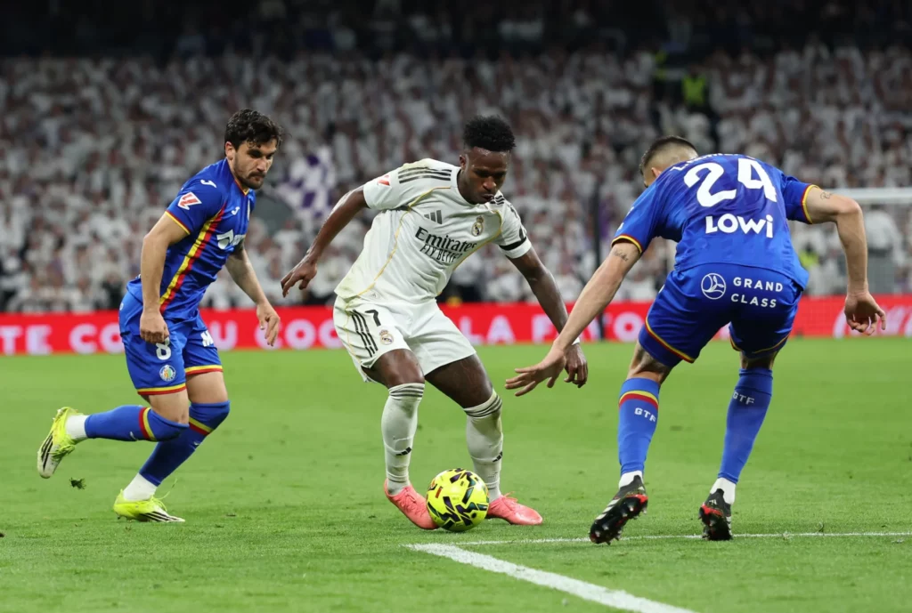 Vinicius, defendido por Arambarri y Romero durante la derrota del Real Madrid ante el Getafe.