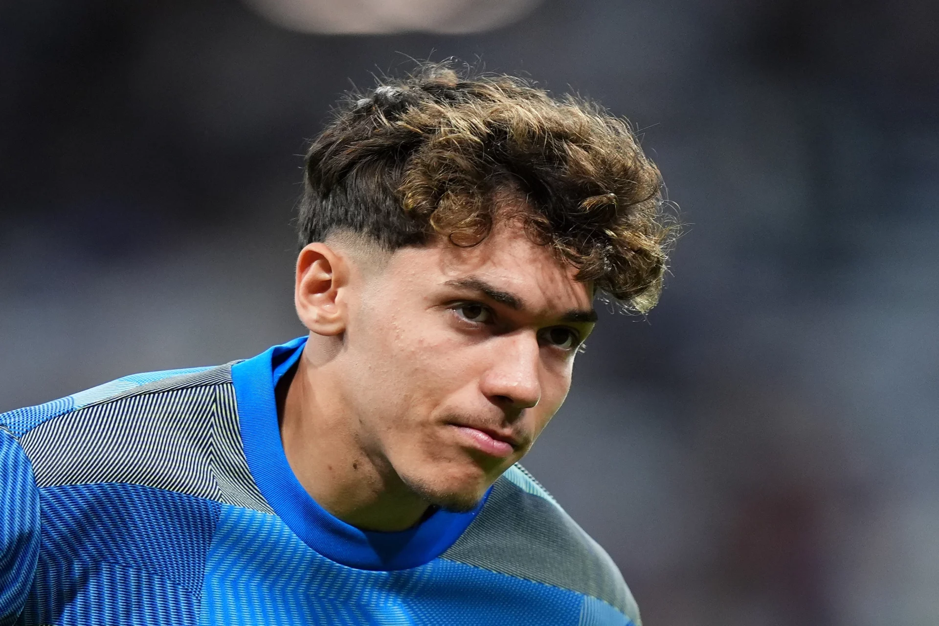 Thiago Pitarch, con gesto serio durante un calentamiento del Real Madrid.