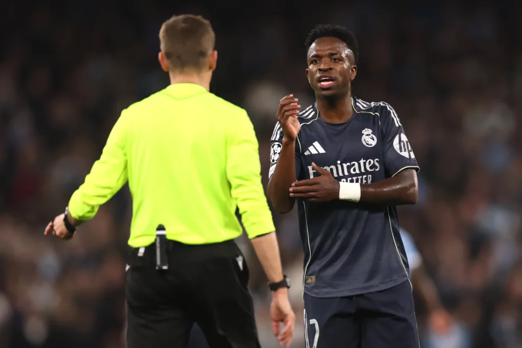 Vinicius Junior habla con el árbitro durante un partido de Champions League.