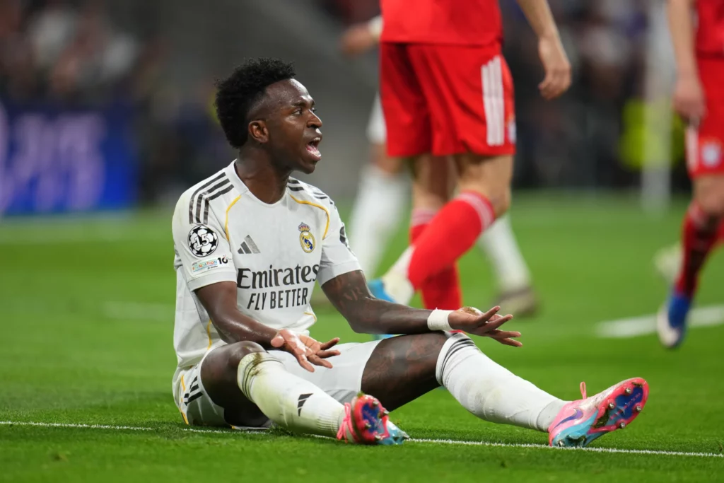 Vinicius protesta con frustración sobre el césped durante el partido entre Real Madrid y Bayern.