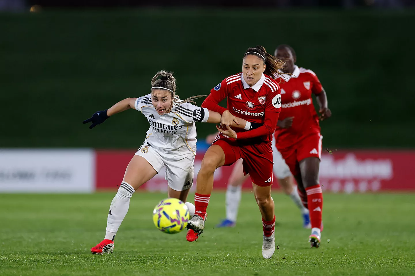 Athenea del Castillo escapa de una jugadora del Sevilla durante un partido con el Real Madrid Femenino.
