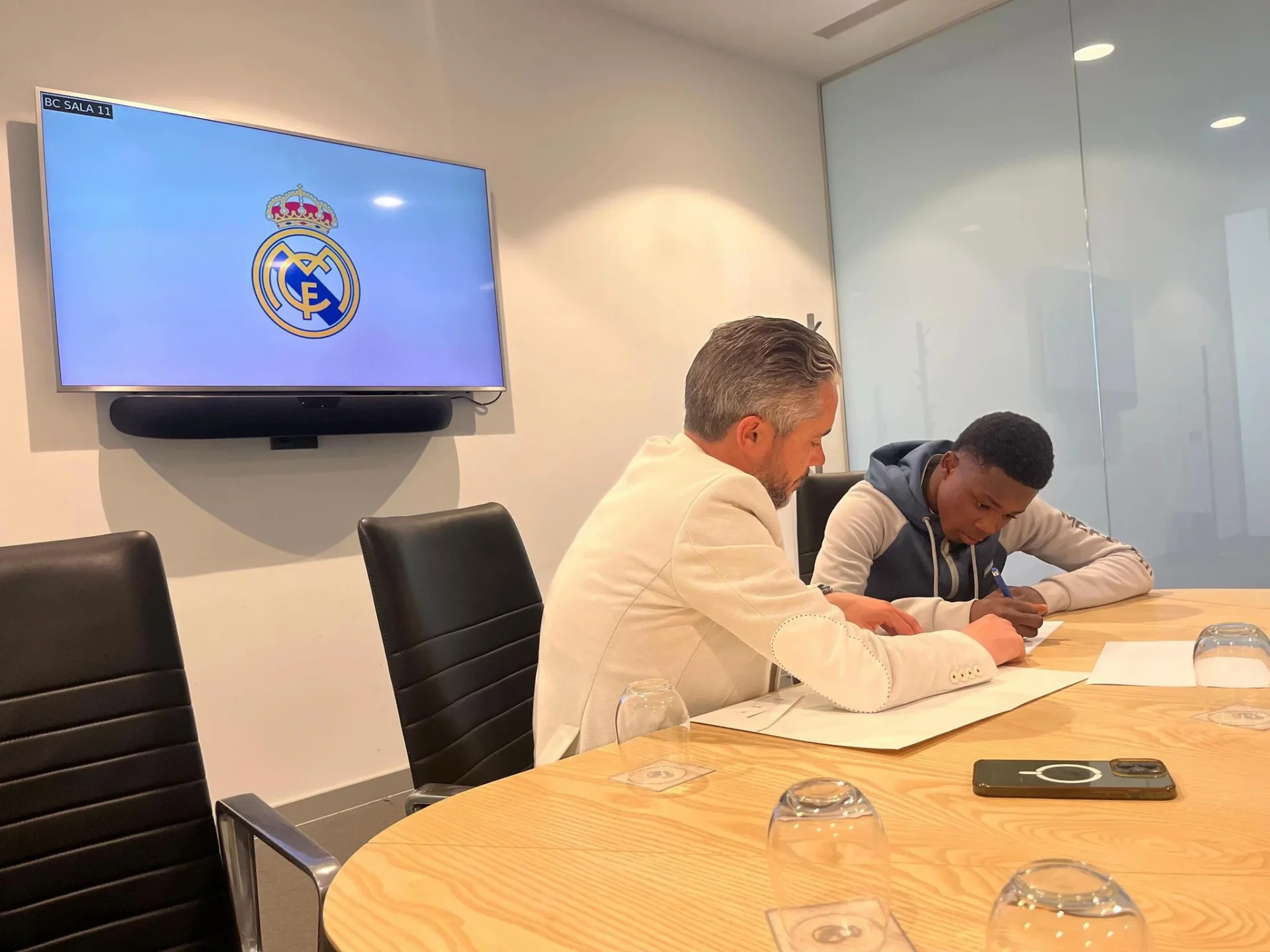 Clifford Nana firma durante su fichaje por la cantera del Real Madrid.