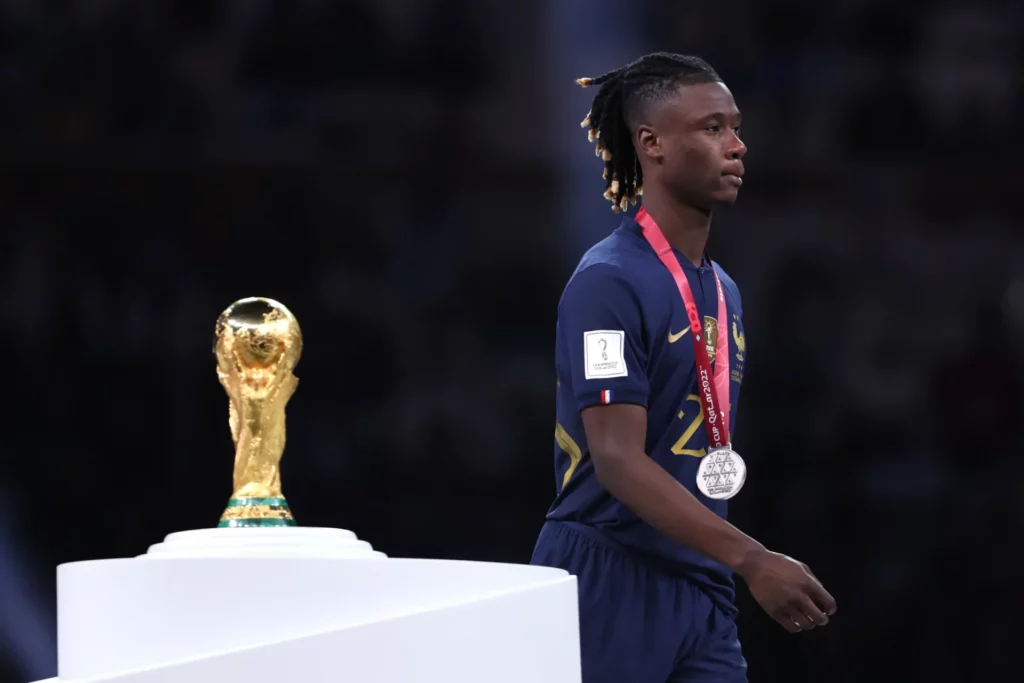 Eduardo Camavinga pasa por detrás del trofeo de campeón tras perder la final del Mundial 2022.