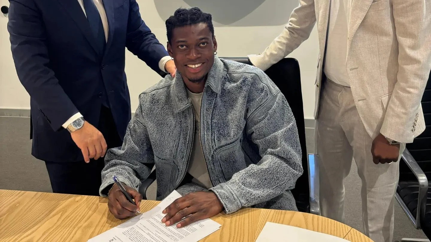Oscar Naasei firma el contrato como parte de su fichaje por el Real Madrid.