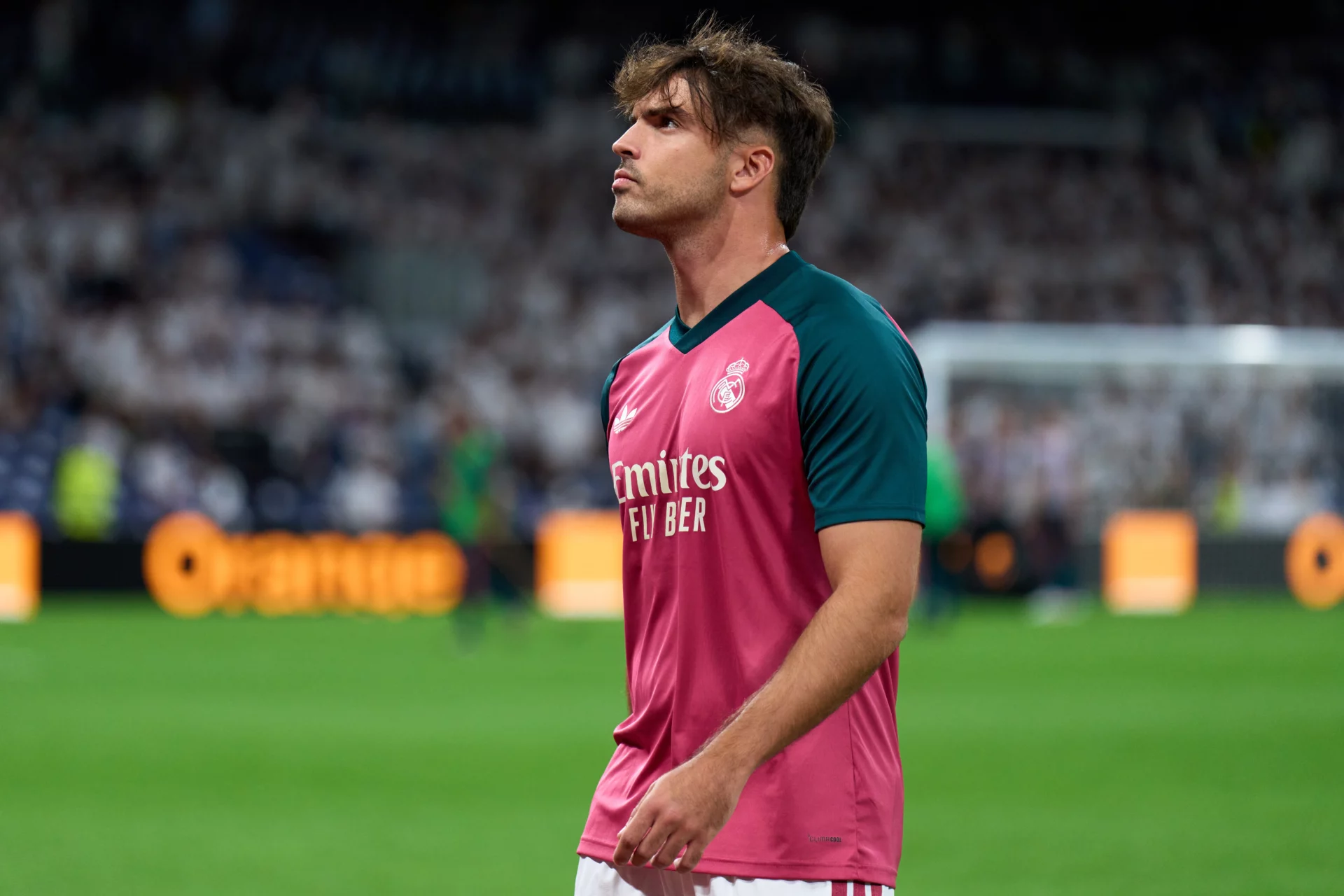 Raúl Asencio, con rostro serio en un calentamiento del Real Madrid en el Bernabéu.