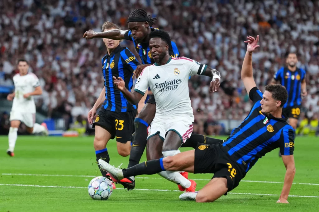 Vinicius recibe la entrada de la defensa del Inter durante la victoria del Real Madrid